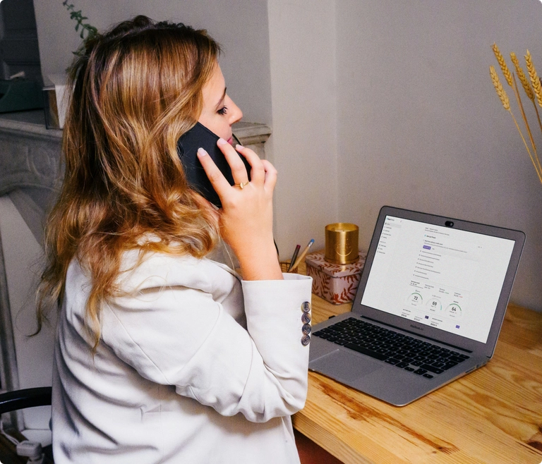 woman on the phone looking at her business finances talking to a business credit coach