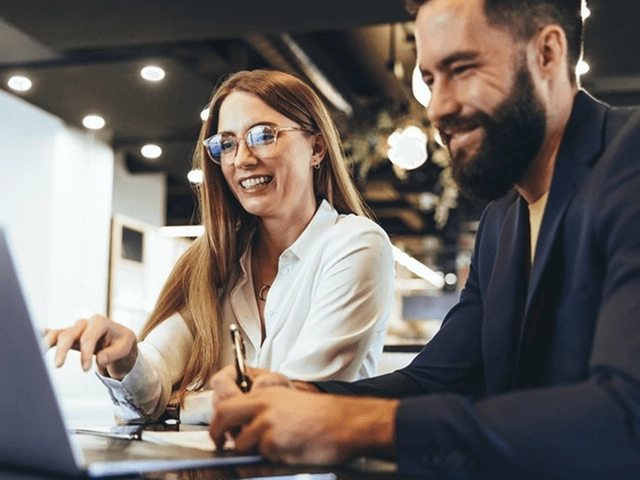 man and woman on computer working together