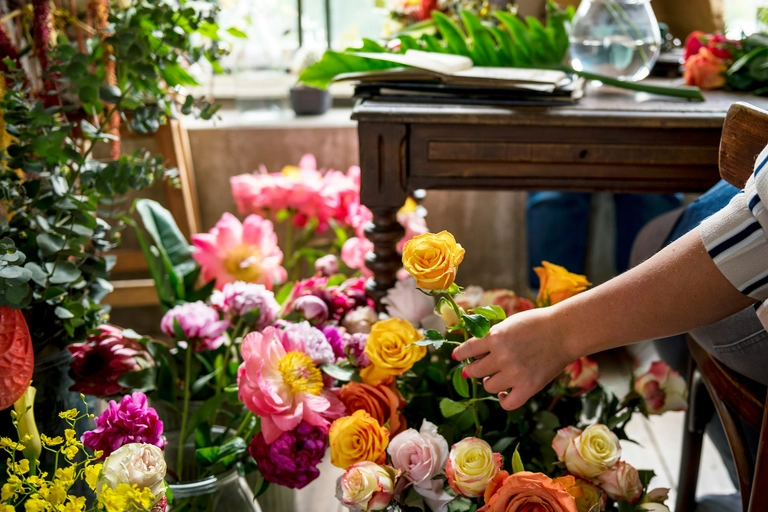 A hand picks out a flower from a colorful array