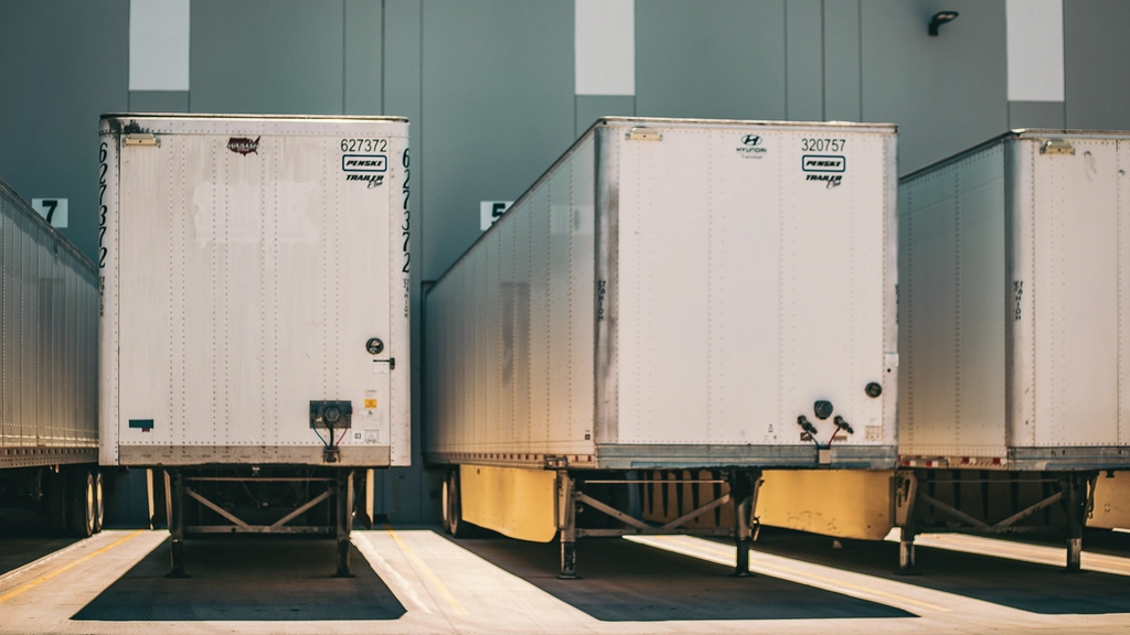 The back of two cargo trucks at a loading dock
