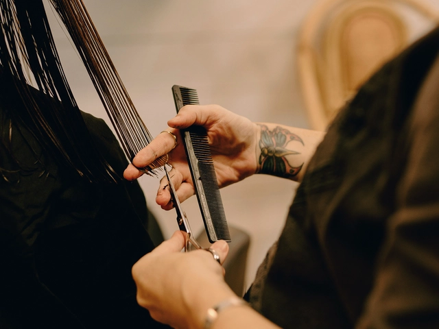 A barber holds a pair of scissors to a client's hair