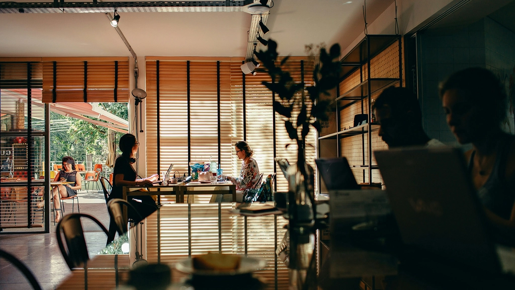 two people sit across from each other at a desk with books