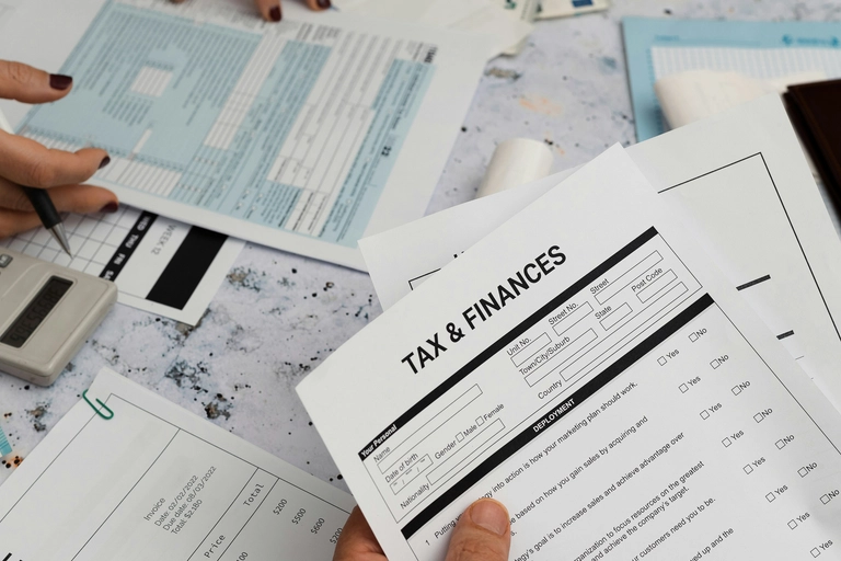 Hand holding tax and financial paperwork