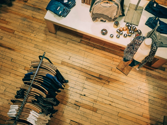 Overhead view of a small clothing boutique with merchandise on a rack and a table