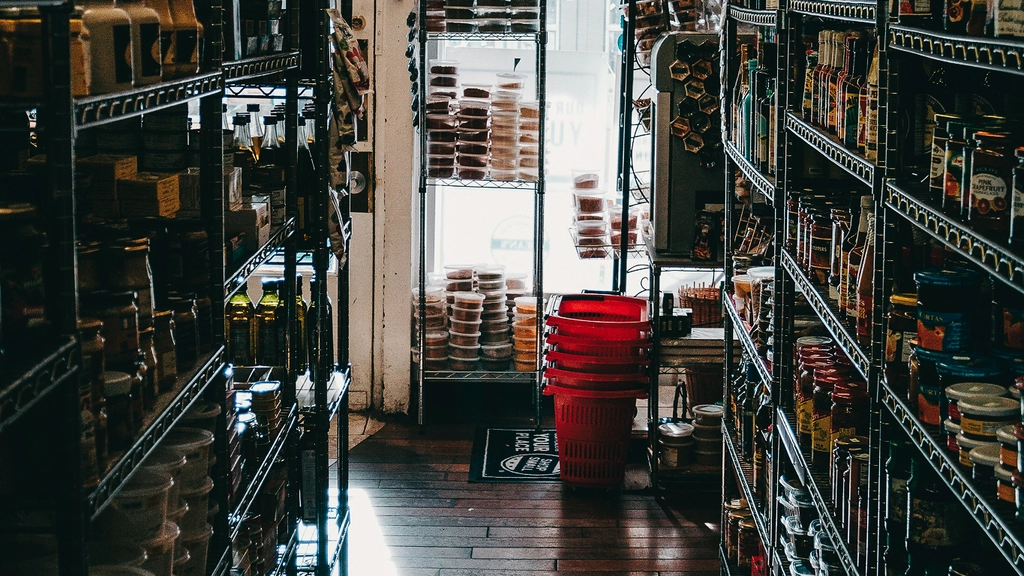View from inside a small convenience store aisle looking through to the storefront window