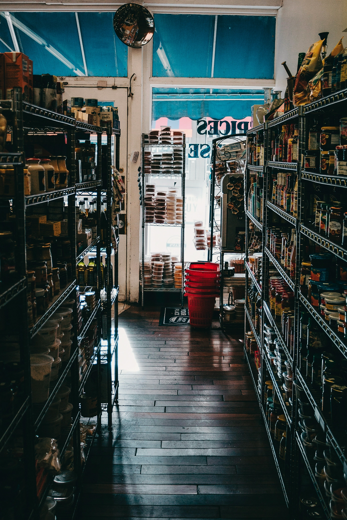 View from inside a small convenience store aisle looking through to the storefront window