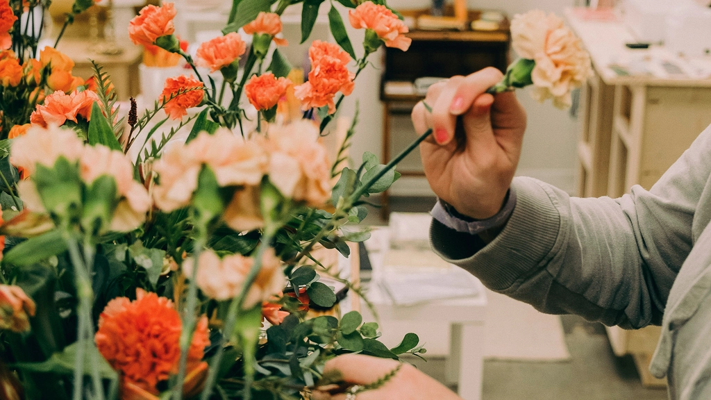 A person picks a flower out of an array of cut flowers