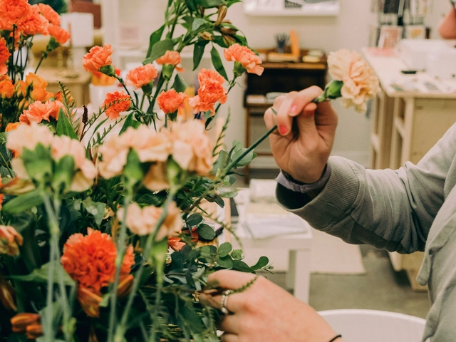A person picks a flower out of an array of cut flowers