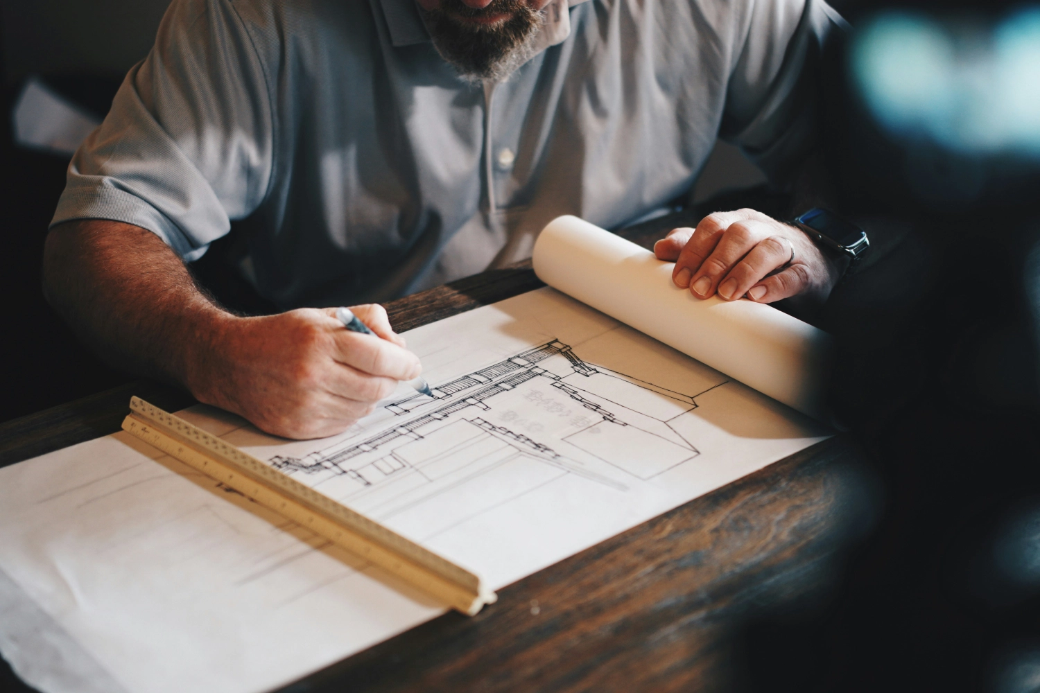 man at a desk reviewing technical drawing