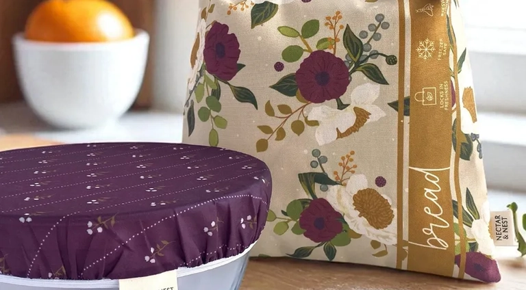 Reusable fabric bread bag and bowl cover with floral patterns from Nectar & Nest displayed on a kitchen counter.