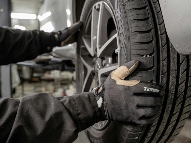 gloved hands holding a wheel, mechanic