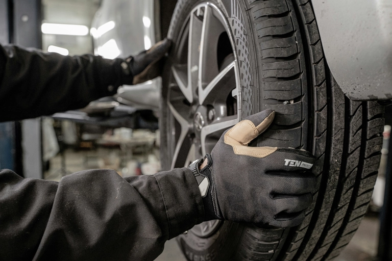 gloved hands holding a wheel, mechanic