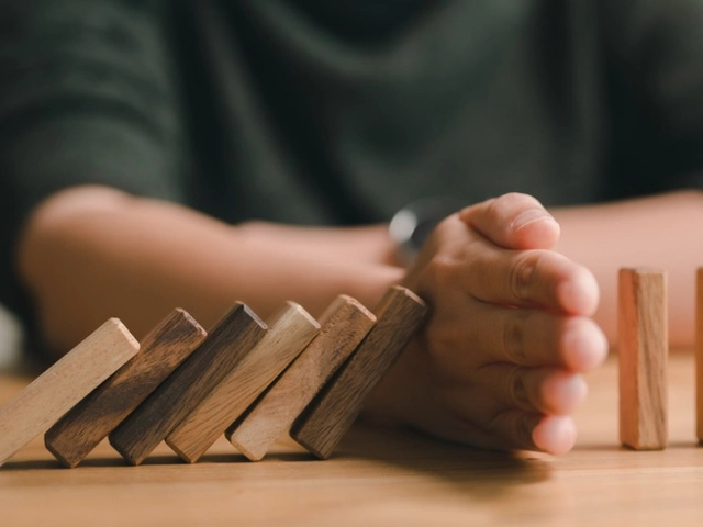 A set of dominos where half are falling and a hand is protecting the other half from going down