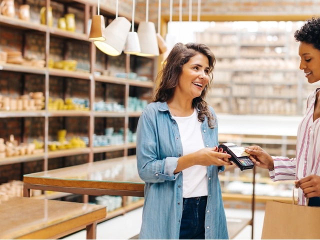 Woman using Arro mastercard to make a purchase at a small business