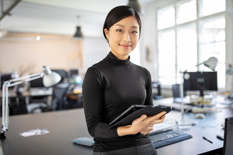business owner smiling with tablet separating business and personal expenses