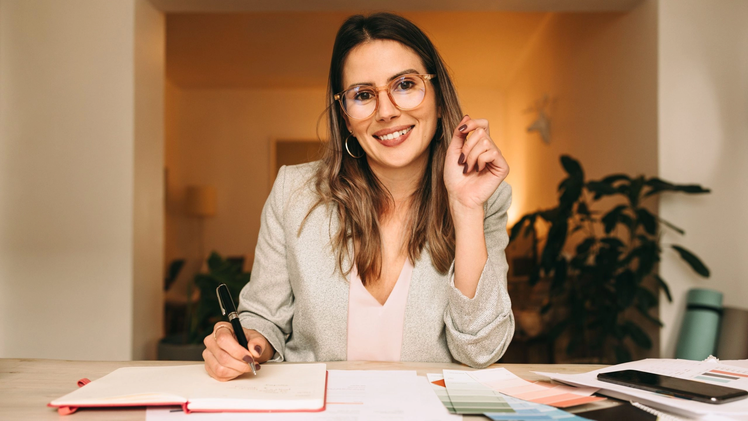 Female business owner with paperwork and pen in hand to illustrate completed business taxes