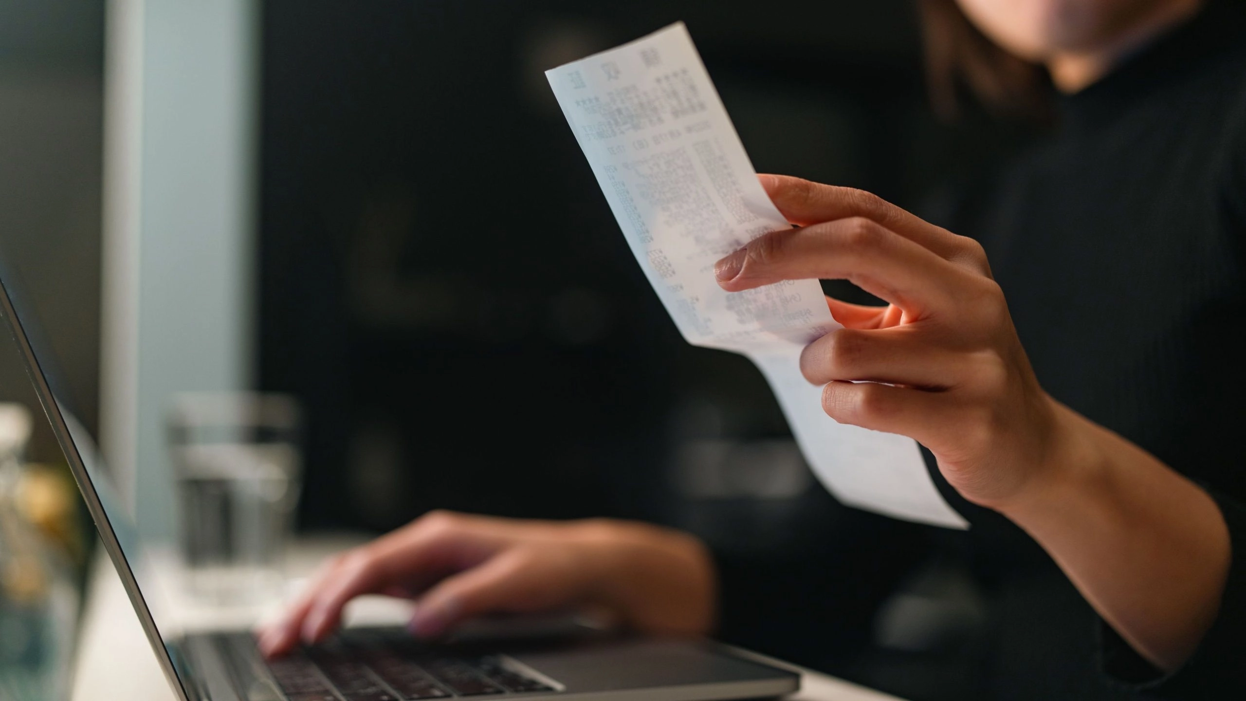 Female Small business owner at a desk reviewing expenses to see if they qualify for tax credit