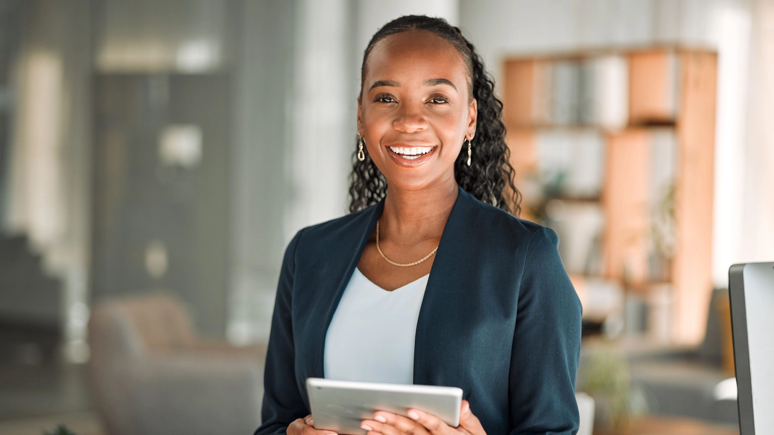 young woman professional in casual suit holding tablet to illustrate article about business credit starter pack