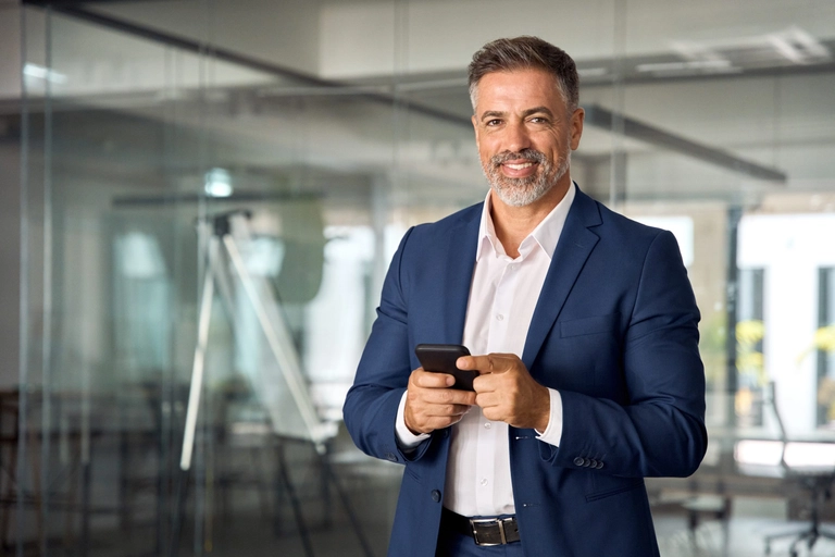 Male business owner in a blue suit smiling to illustrate article about business credit score factors.