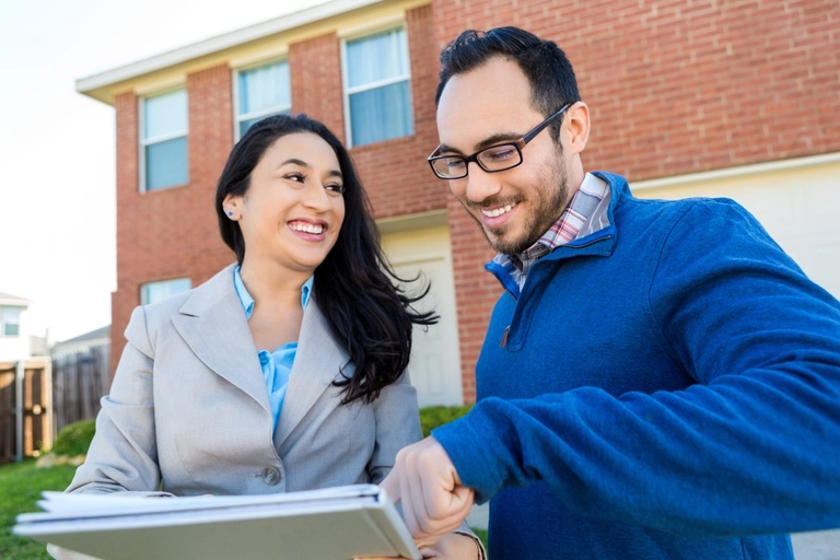 business owners reviewing business checking account standing in front of airbnb house