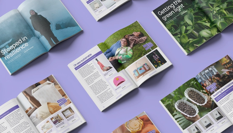 Colorful flat lay of open magazines on a purple background featuring small business stories, sustainable products, and community highlights.