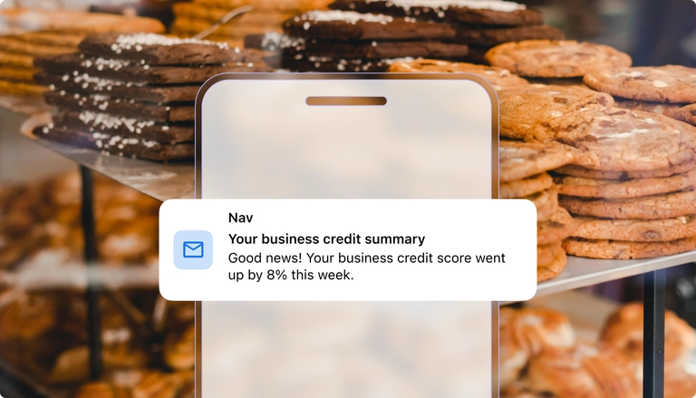 Notification stating business credit score increased by 8%, with cookies stacked in the background