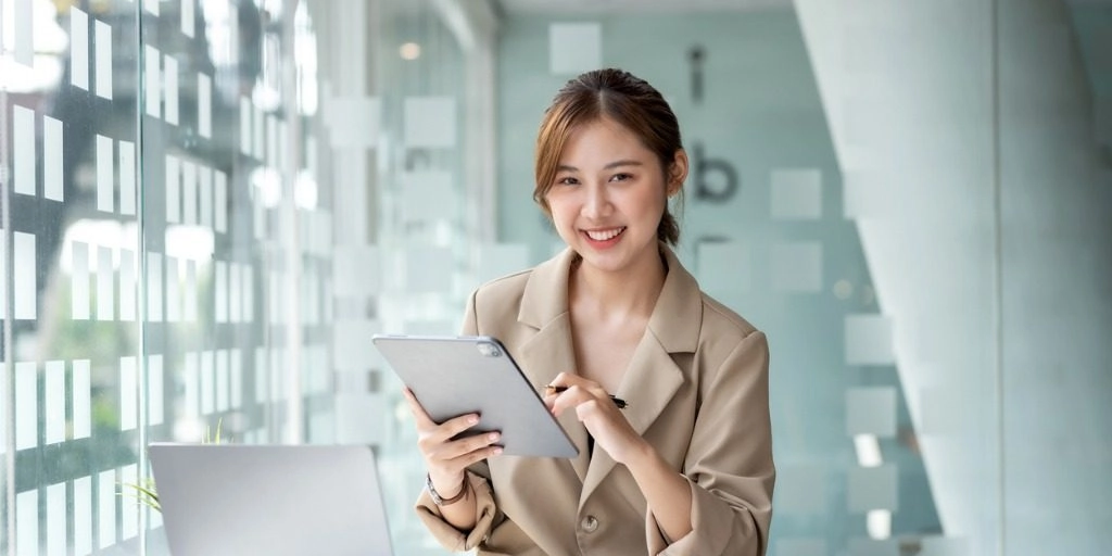 Young woman smiling with a tablet to illustrate article about personal vs business insurance
