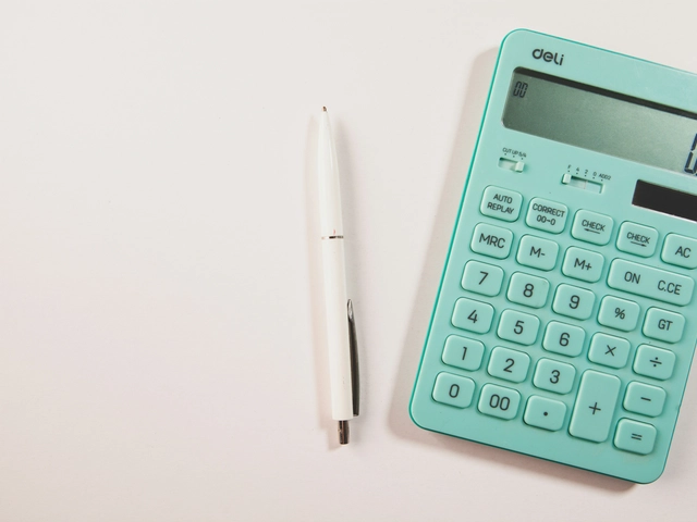 a teal calculator next to a white pen on a white background