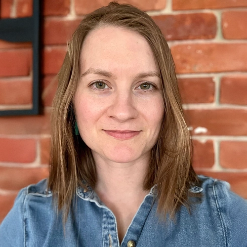 Headshot of a woman against a brick wall