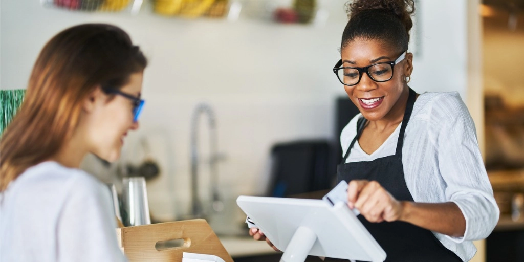 Woman Small business owner swiping a customer's credit card