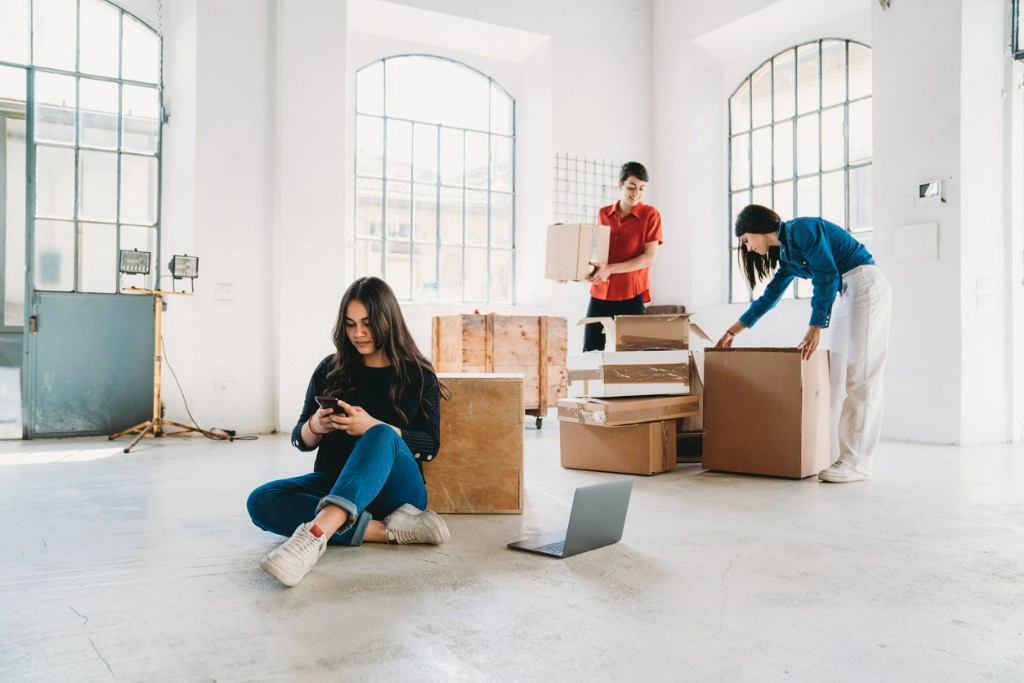 A group of small business owners unpacks boxes while one starts an llc